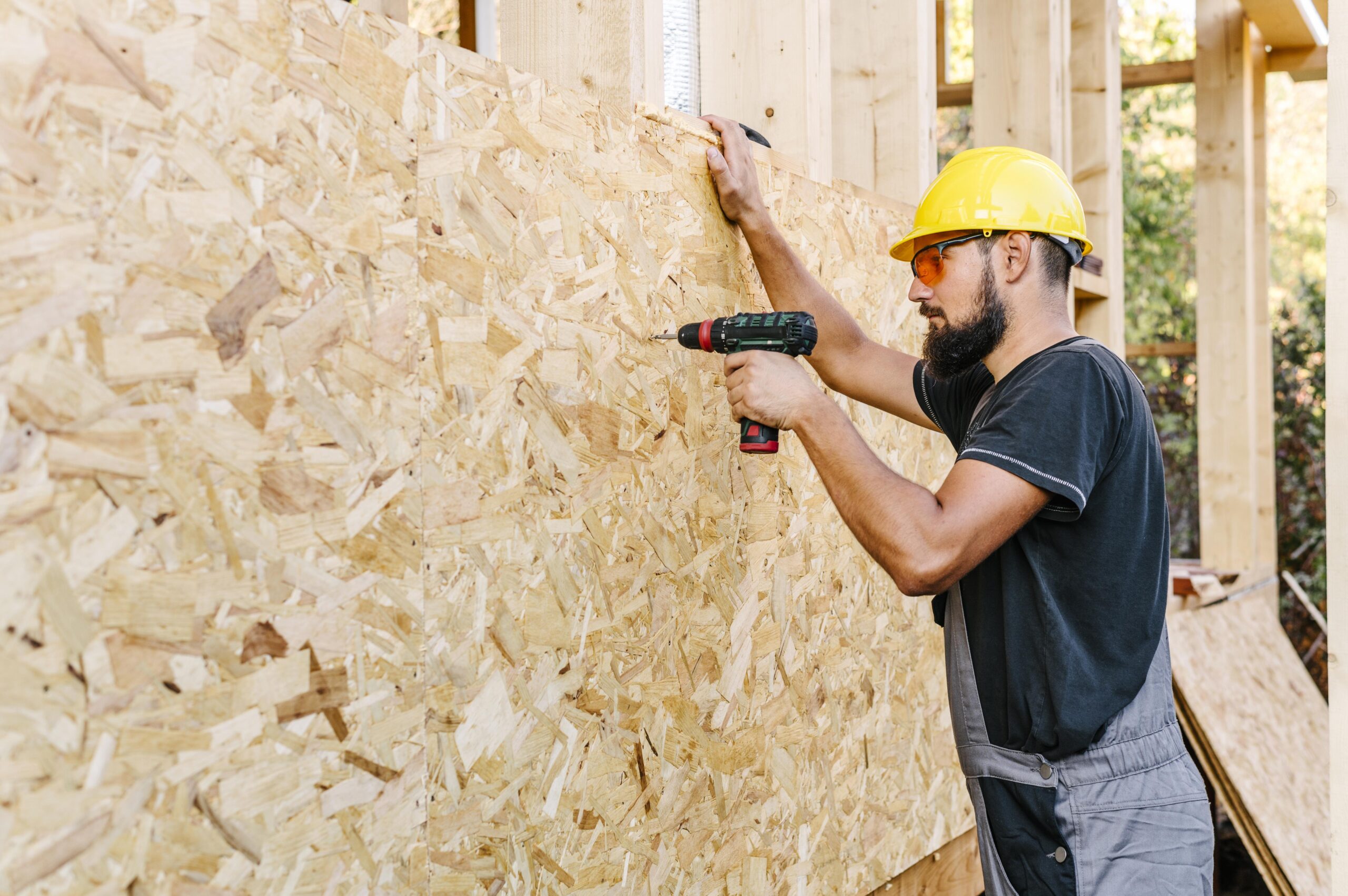 side-view-construction-worker-drilling-plywood-with-copy-space